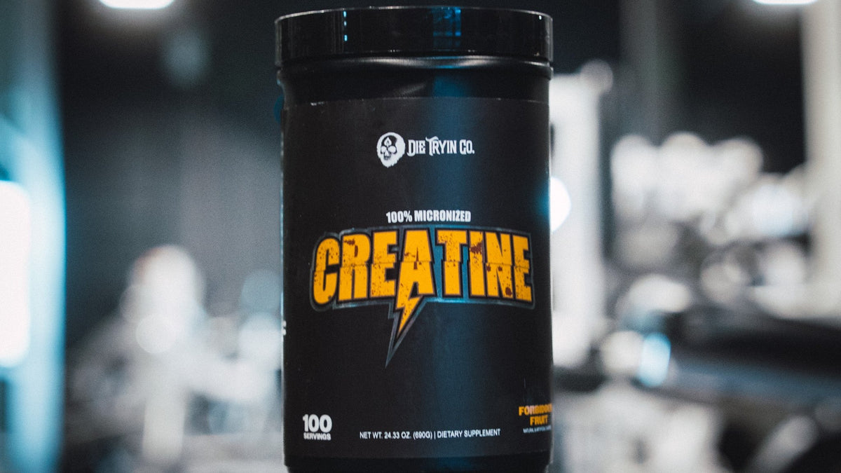 Die Tryin Co. 100% Micronized Creatine tub in Forbidden Fruit flavor in a dark gym