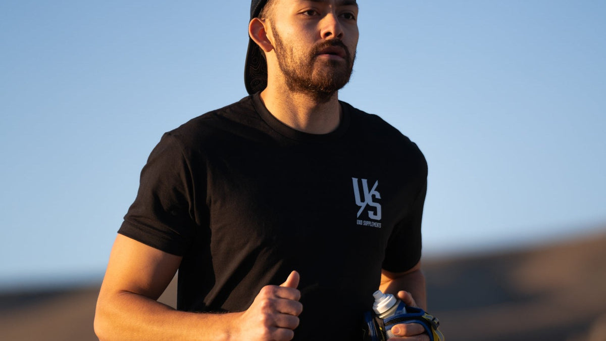 Runner in a black Die Tryin tee mid-stride against a clear sky