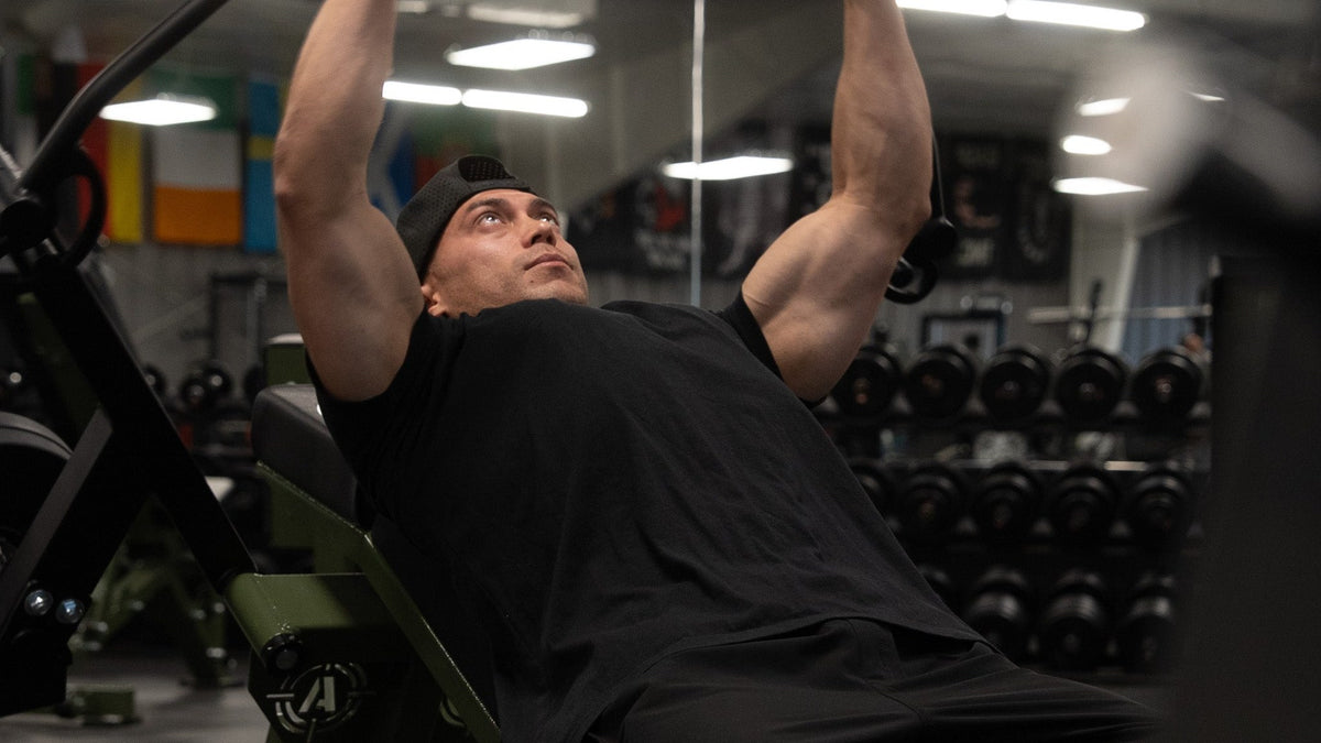 Athlete pressing on an incline machine in a dark gym
