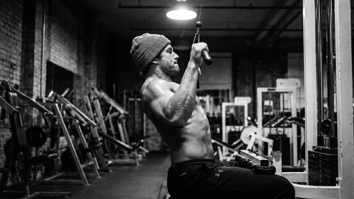 Lifter holding the stretch at the top of a lat pulldown during a back workout