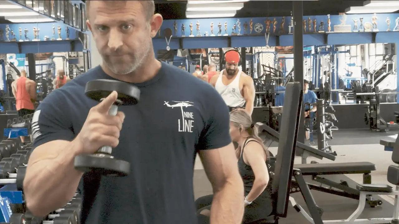 Pinky-up lateral raise demonstrating the grip variation for medial delt isolation
