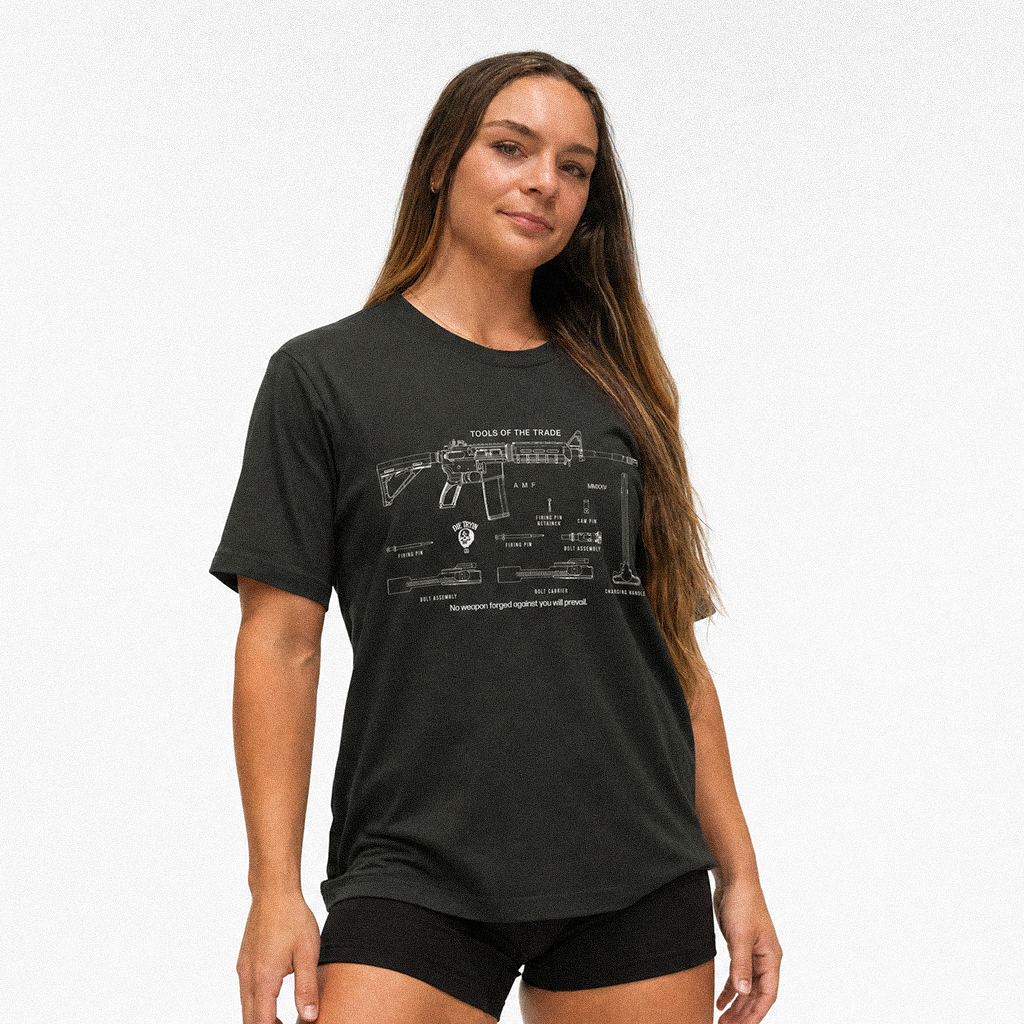 Woman in a black tee with a white rifle schematic print titled Tools of the Trade