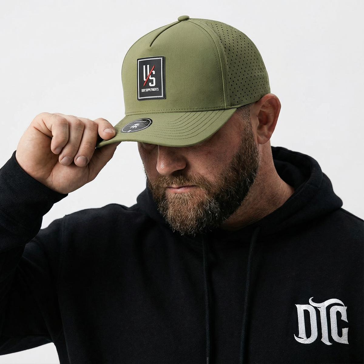 Olive PVC-patch hat worn with a Die Tryin Co. zip-up