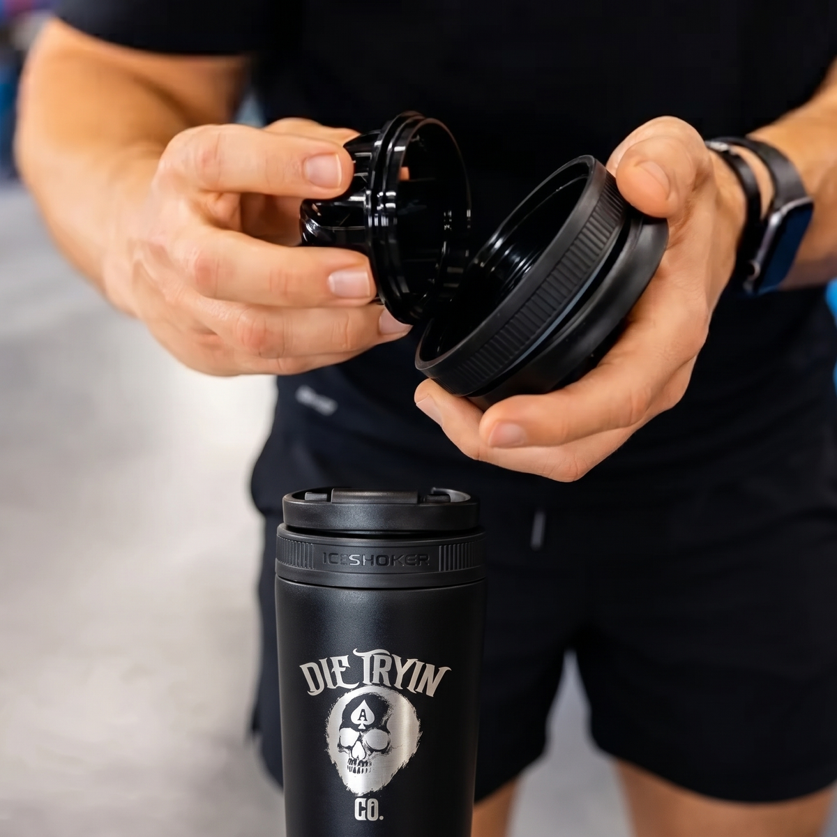 Man twisting apart a black shaker attachment above a black IceShaker bottle engraved with the Die Tryin Co. skull logo