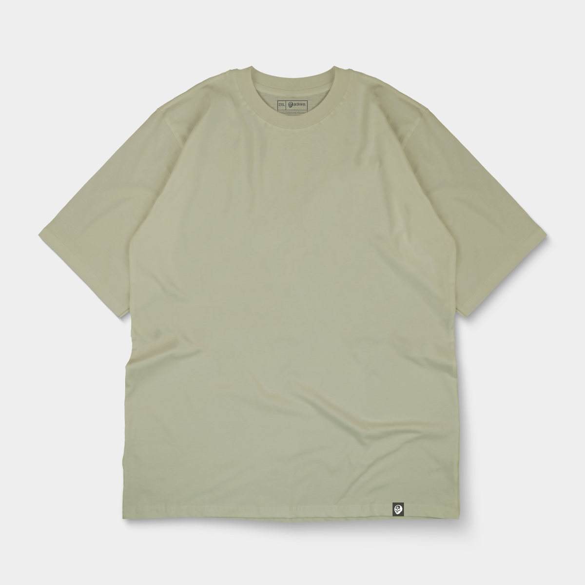 Oversized tagged tee flat lay in sand